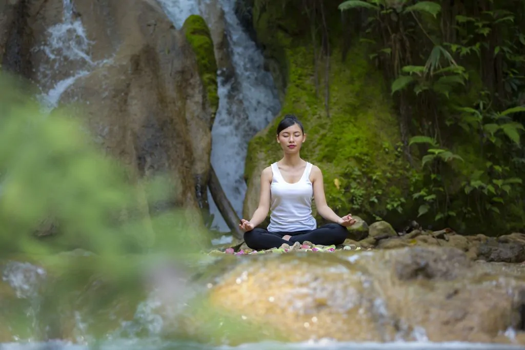 How to improve mental health 3. Meditate ( A person meditating in a peaceful place)